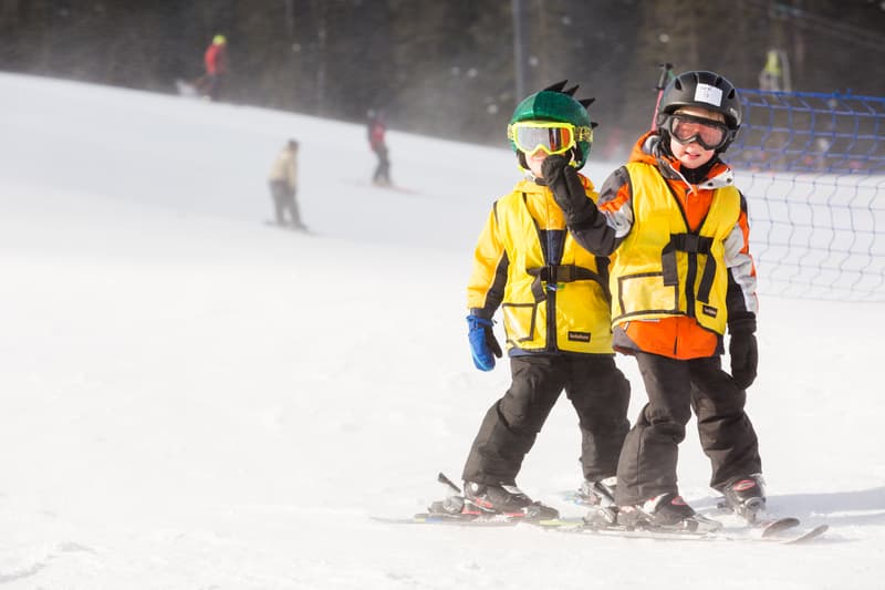 Kids skiing with yellow jackets