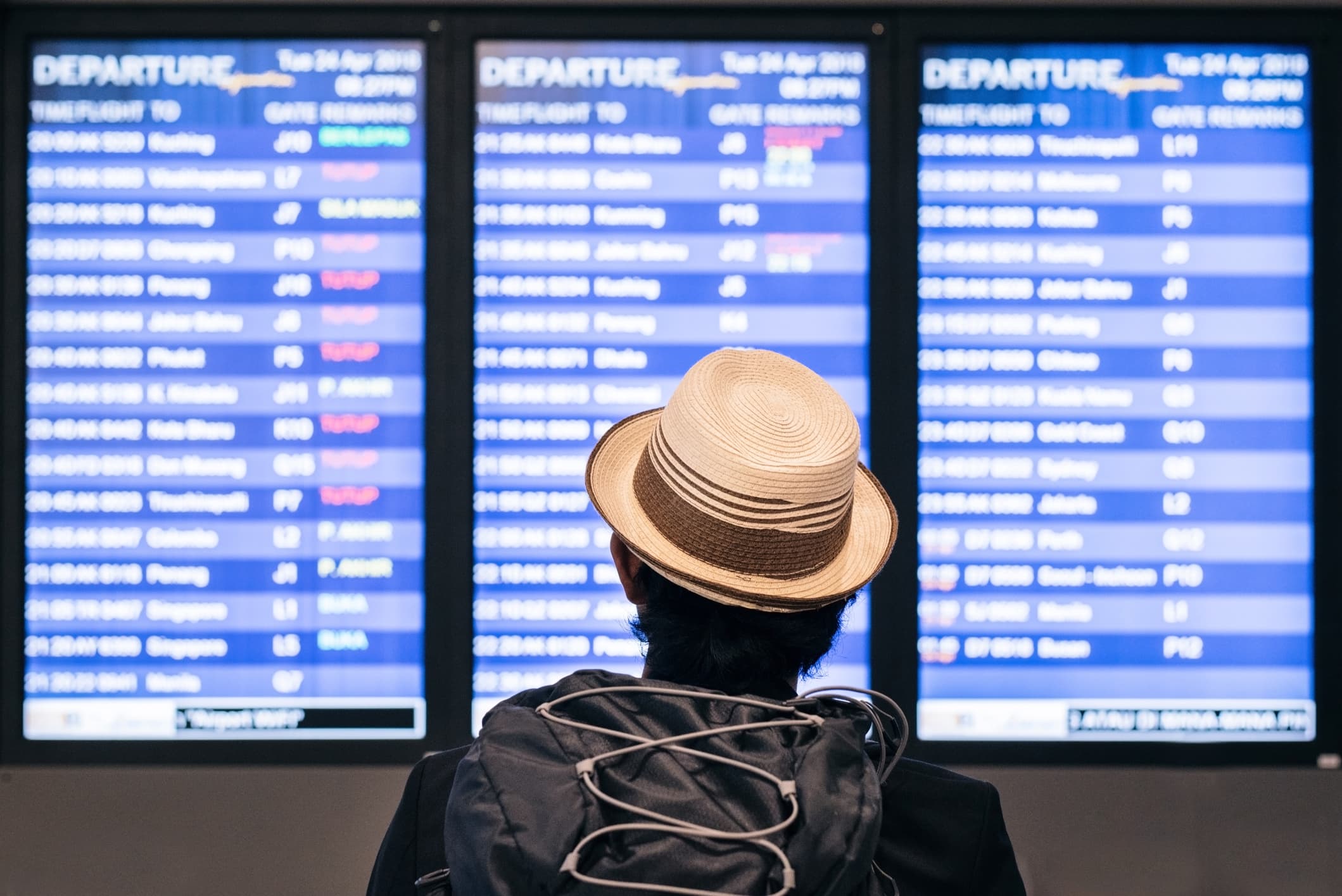 man looking at flight schedules at airport