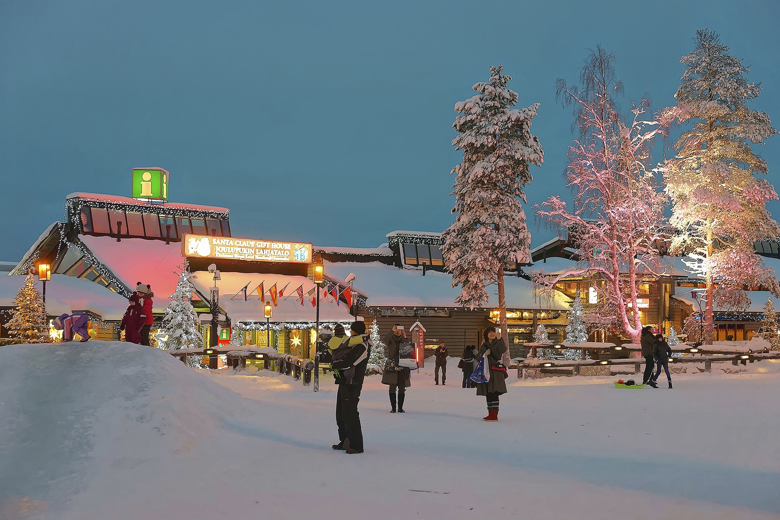 Families in the snow visiting Santa Claus Village in Finnish Lapland