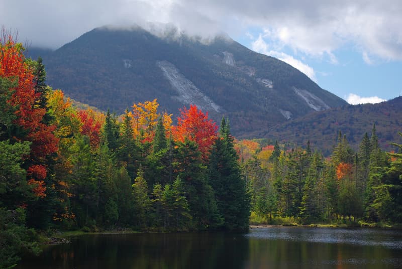 A view of a lake, bright fall colors, and the Adirondack Mountains
