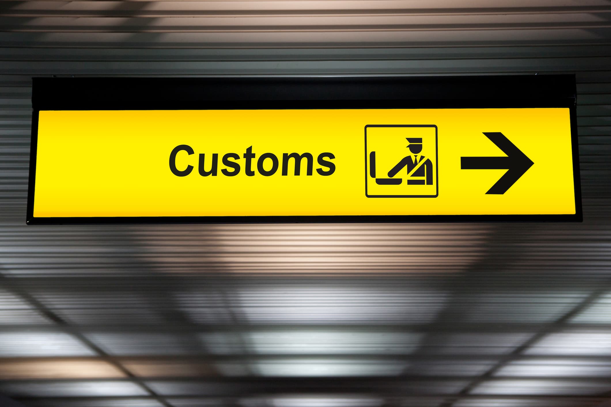 A view of an airport customs sign with an arrow.