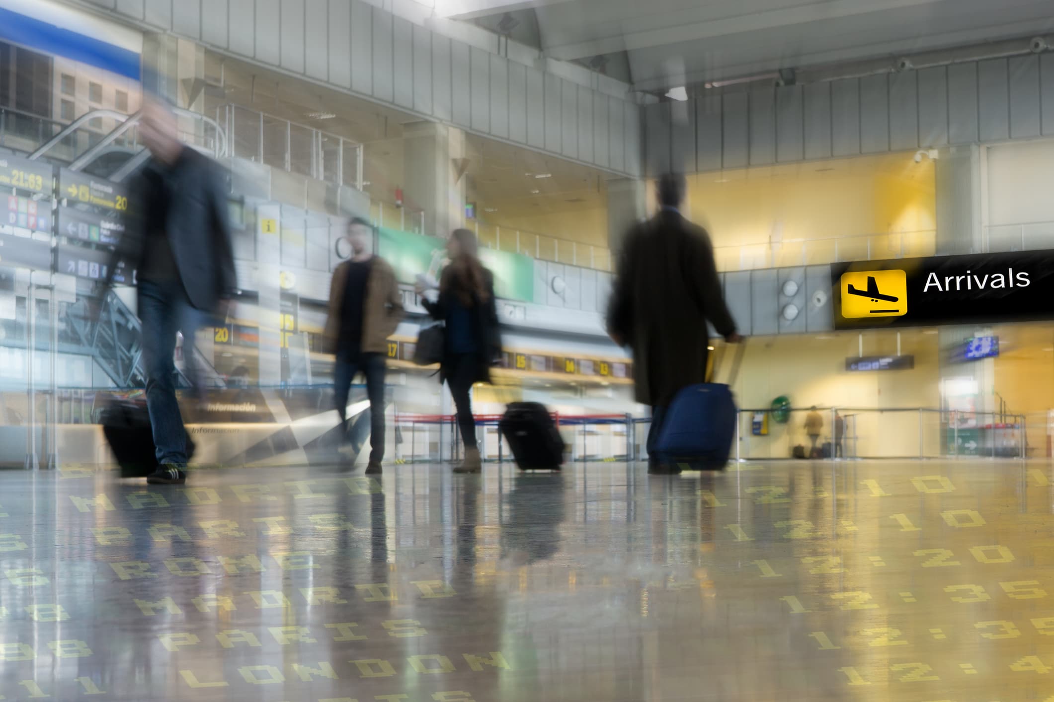 An image of airport passengers moving qjuickly through a terminal