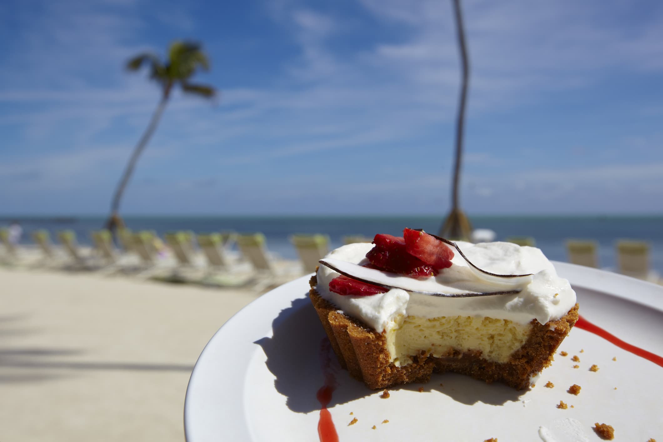 A slice of Key Lime pie on a tropical beach.