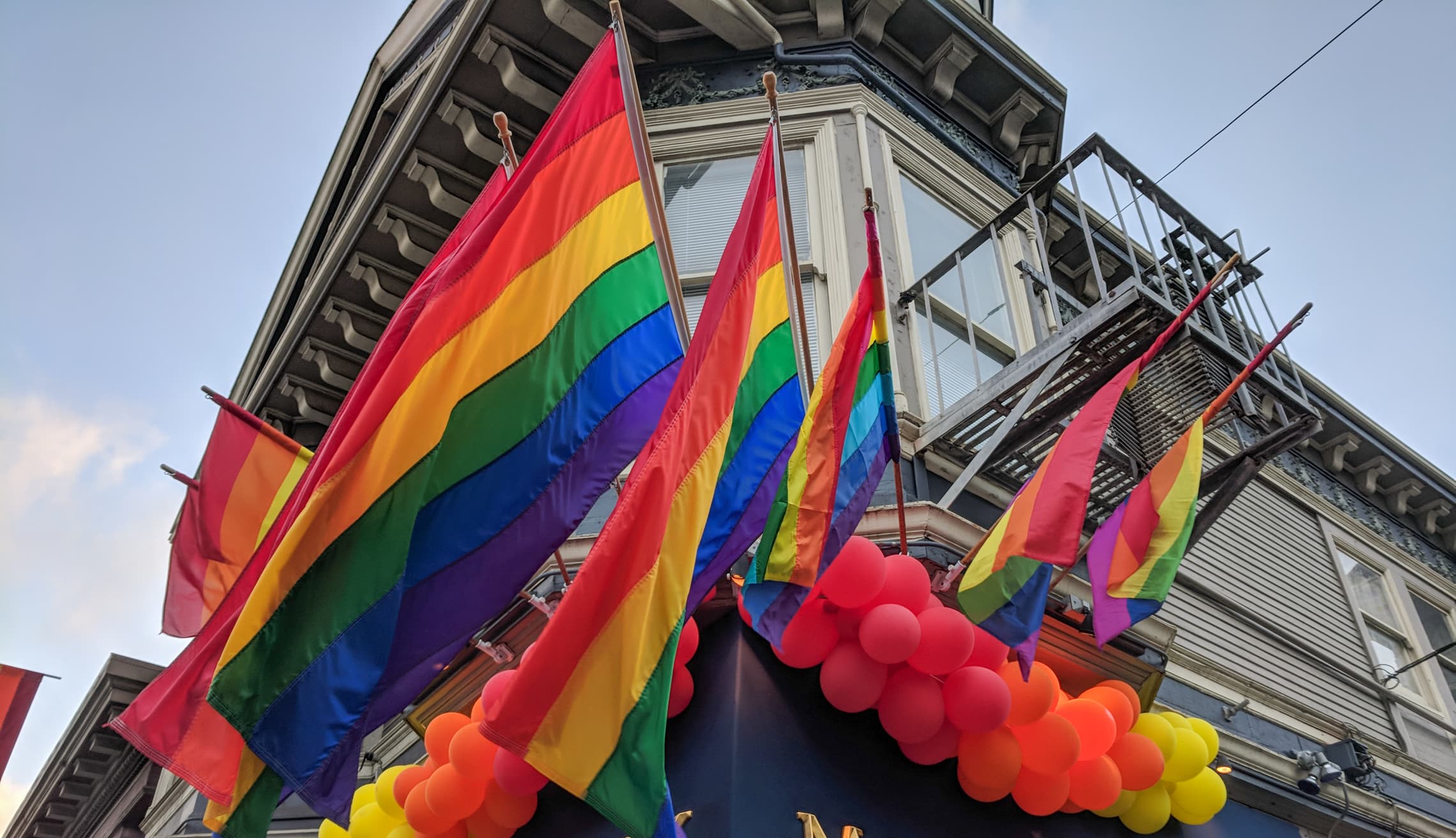 Rainbow pride flags decorate a Victorian-style building in San Francisco's Castro District
