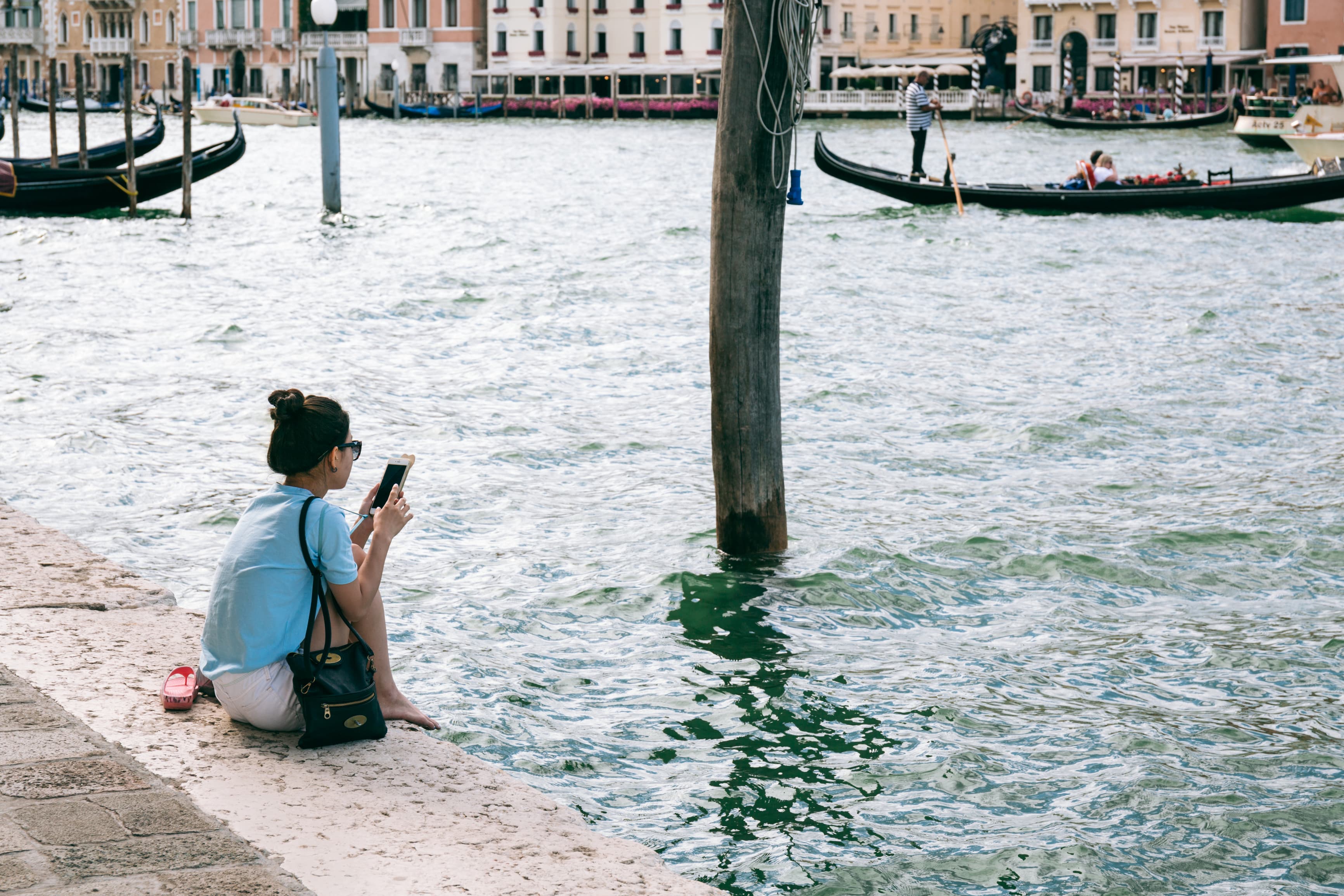 Woman on Venice on Mobile phone by canal